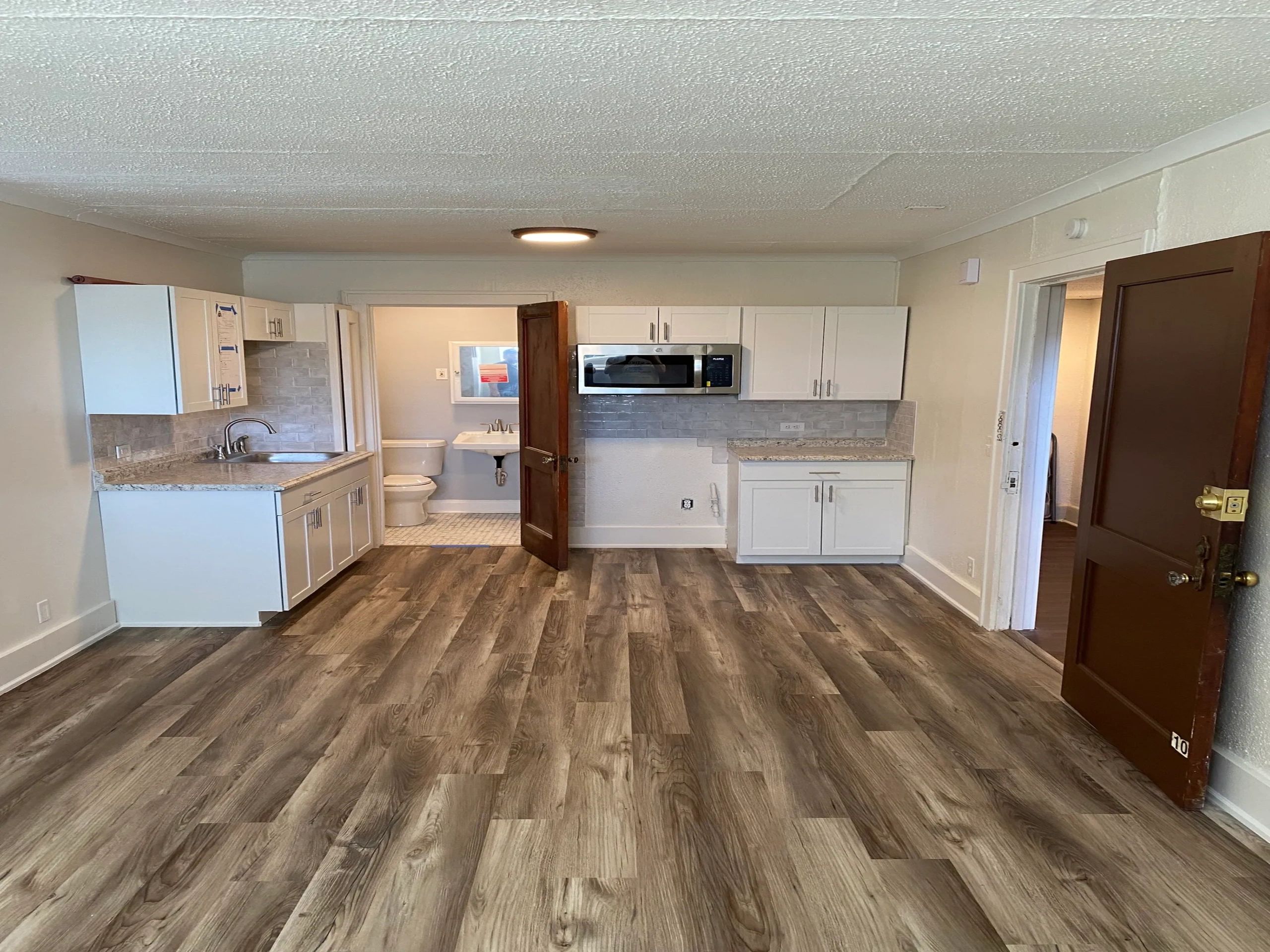 A renovated interior they published on their current site — kitchenette, bath, and new floors.